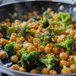 Close-up of a vibrant stir-fried dish featuring broccoli and chickpeas.