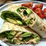 Close-up view of a fresh avocado tuna wrap, showcasing the vibrant ingredients inside.