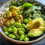 Close-up view of a vibrant Edamame Avocado Buddha Bowl with colorful ingredients.