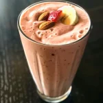 Close-up of a refreshing protein smoothie in a glass, showcasing vibrant colors of strawberries and banana.