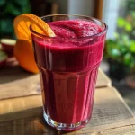 Close-up view of a vibrant red Rote Bete smoothie in a glass, showcasing its rich color and texture.