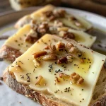 Close-up view of Ziegenkäse drizzled with honey and garnished with walnuts.