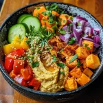 Close-up of a colorful roasted veggie hummus bowl with vibrant vegetables and a creamy hummus base.