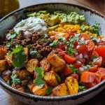 Close-up of a flavorful Kartoffel Taco Bowl with beef, potatoes, and fresh toppings.