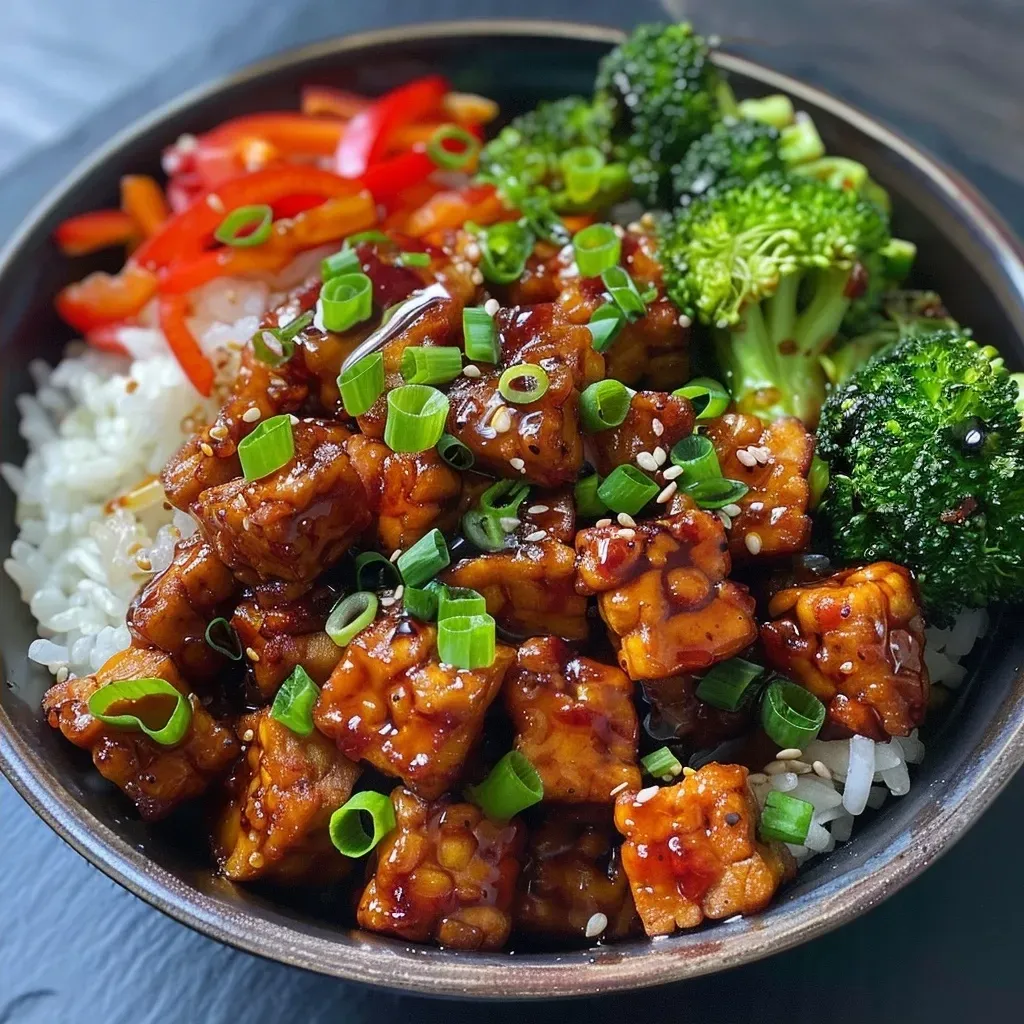 Side view of a vibrant tempeh stir-fry with vegetables in a pan.
