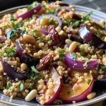 Close-up of baked aubergine topped with couscous and garnishes.