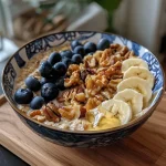 Close-up view of a warm millet bowl topped with sliced pears, almonds, and a sprinkle of cinnamon.